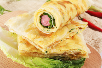 黄色的鸡蛋灌饼放在木纹桌面上