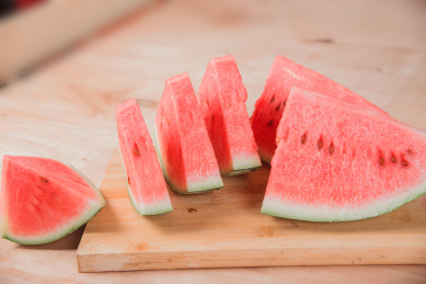 木板背景上放着几片红色的西瓜