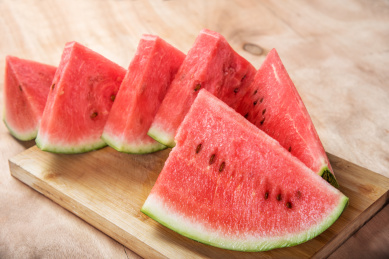 木板背景上放着几片红色的西瓜