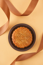 黄色背景下丝带装饰的红豆月饼