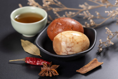 煮熟的茶叶蛋盛放在碟子和碗中摆放在桌面上