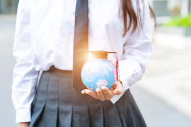 一个美女手里拿着地球仪象征着学习教育机构培训毕业季毕业高学历概念