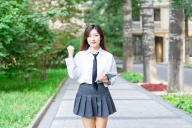 一个美女大学生校园内抱着书本准备学习自习去图书馆看书