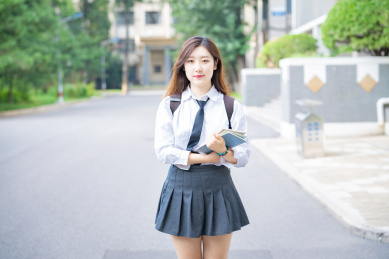 一个美女大学生校园内抱着书本准备学习自习去图书馆看书