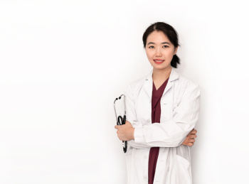 站在白色背景前拿听诊器的中国女性医生