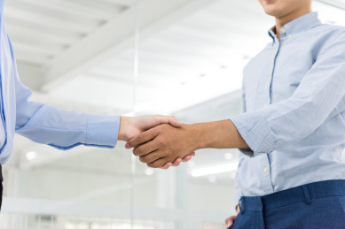 亚洲男性和女性在办公室里握手，合作成功概念