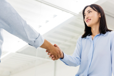 亚洲男性和女性在办公室里握手，合作成功概念