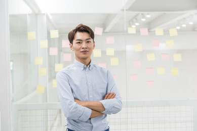 年轻的亚洲商务男性在办公室，便利贴背景