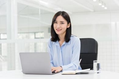 笔记本电脑前的亚洲职业女性，现代办公场景