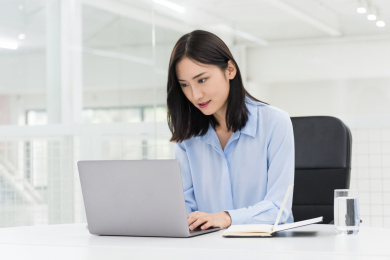 笔记本电脑前的亚洲职业女性，现代办公场景