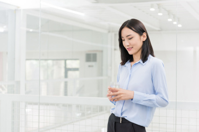 职业女性在办公室拿着一杯水