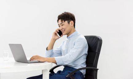 年轻的亚洲商务男性在室内使用智能手机