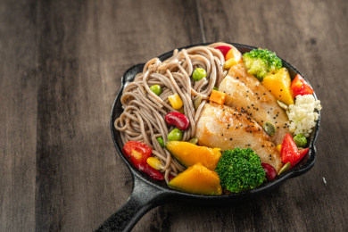 暗色木纹桌面上放着一盘油煎龙利鱼荞麦面