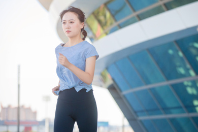 户外体育场里，正在做热身运动的亚洲女孩