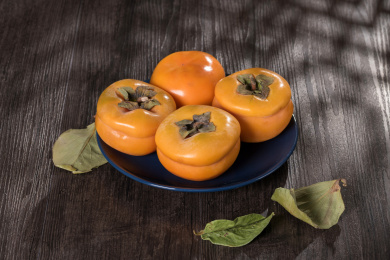 成熟的甜柿子摆放在桌面上