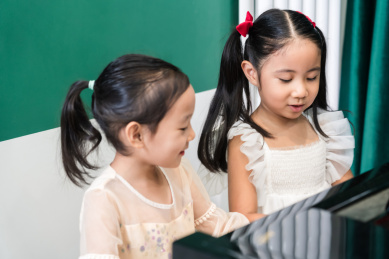 两个正在弹奏钢琴的中国女孩