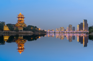 中国四川省绵阳市涪江畔的越王楼和城市现代建筑夜景和江里的倒影