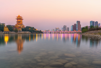 中国四川省绵阳市涪江畔的越王楼仿古建筑和城市现代建筑夜景和江里的倒影