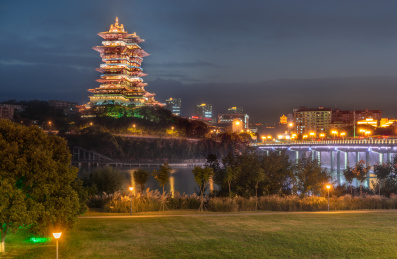 中国四川省绵阳市涪江畔的越王楼仿古建筑夜景和江边的湿地公园绿地