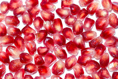 放在白色背景上剥成一粒粒的石榴籽特写