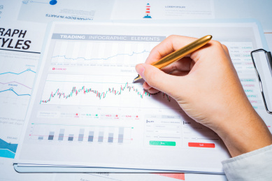 一个商务金融人士手拿着报表图表进行分析解析计算概念