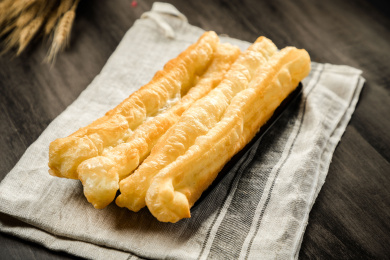 棕色木纹桌面上放着两根炸油条