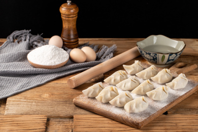 很多新鲜手工水饺摆放在木板背景上