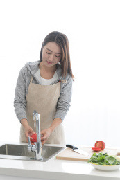 一名年轻女性在厨房烹饪洗菜