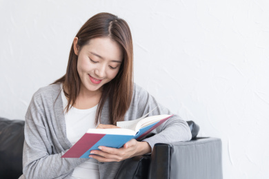 一名年轻女性在沙发上愉快地看书