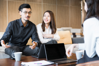 一名男性员工在咖啡厅与他人讨论中积极发言