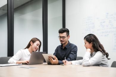 会议中三名年轻员工讨论工作方案