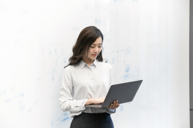 一名年轻女性员工在会议中看着笔记本电脑