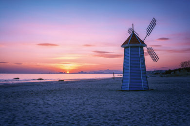 傍晚宁静的海洋上霞光照耀在风车上