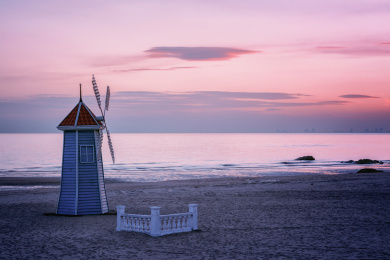 傍晚宁静的海洋上霞光照耀在风车上