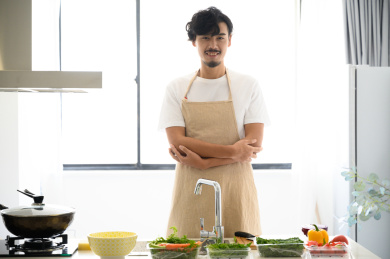 年轻亚洲男人在家做饭