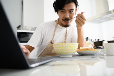 年轻亚洲男人在家吃早饭
