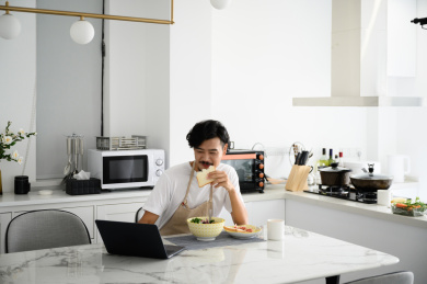 年轻亚洲男人在家吃早饭