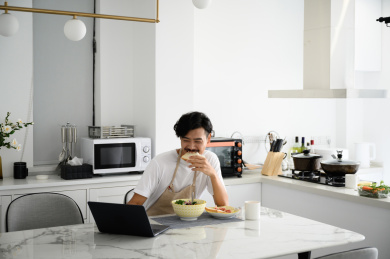 年轻亚洲男人在家吃早饭