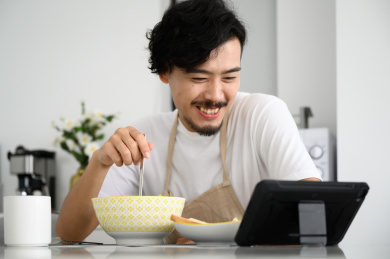 年轻亚洲男人在家吃早饭