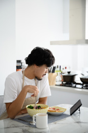 年轻亚洲男人在家吃早饭