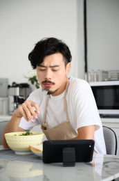 年轻亚洲男人在家吃早饭