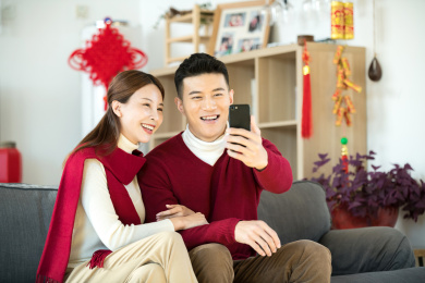 一对情侣在用手机拜年