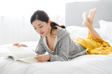 在室内居家卧室阅读杂志书籍的女性