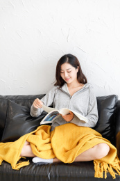 在客厅沙发上戴着耳机听音乐的女生