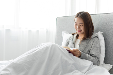 一名年轻女士在卧室看书放松