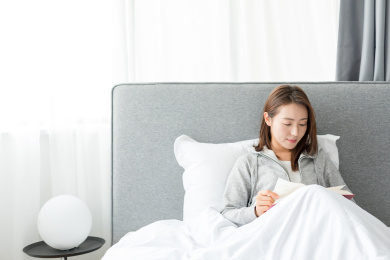 一个年轻女士在卧室靠着看书