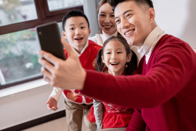 一个年轻的中国家庭开心的在一起用电话视频聊