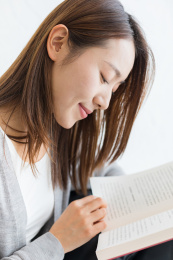 一个年轻女性在家坐着看书阅读特写