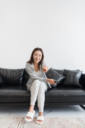 坐在沙发看向前方电视的年轻女性