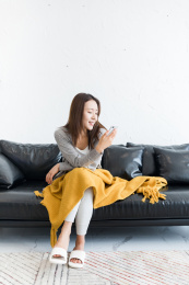 一个年轻女性坐在沙发上看手机